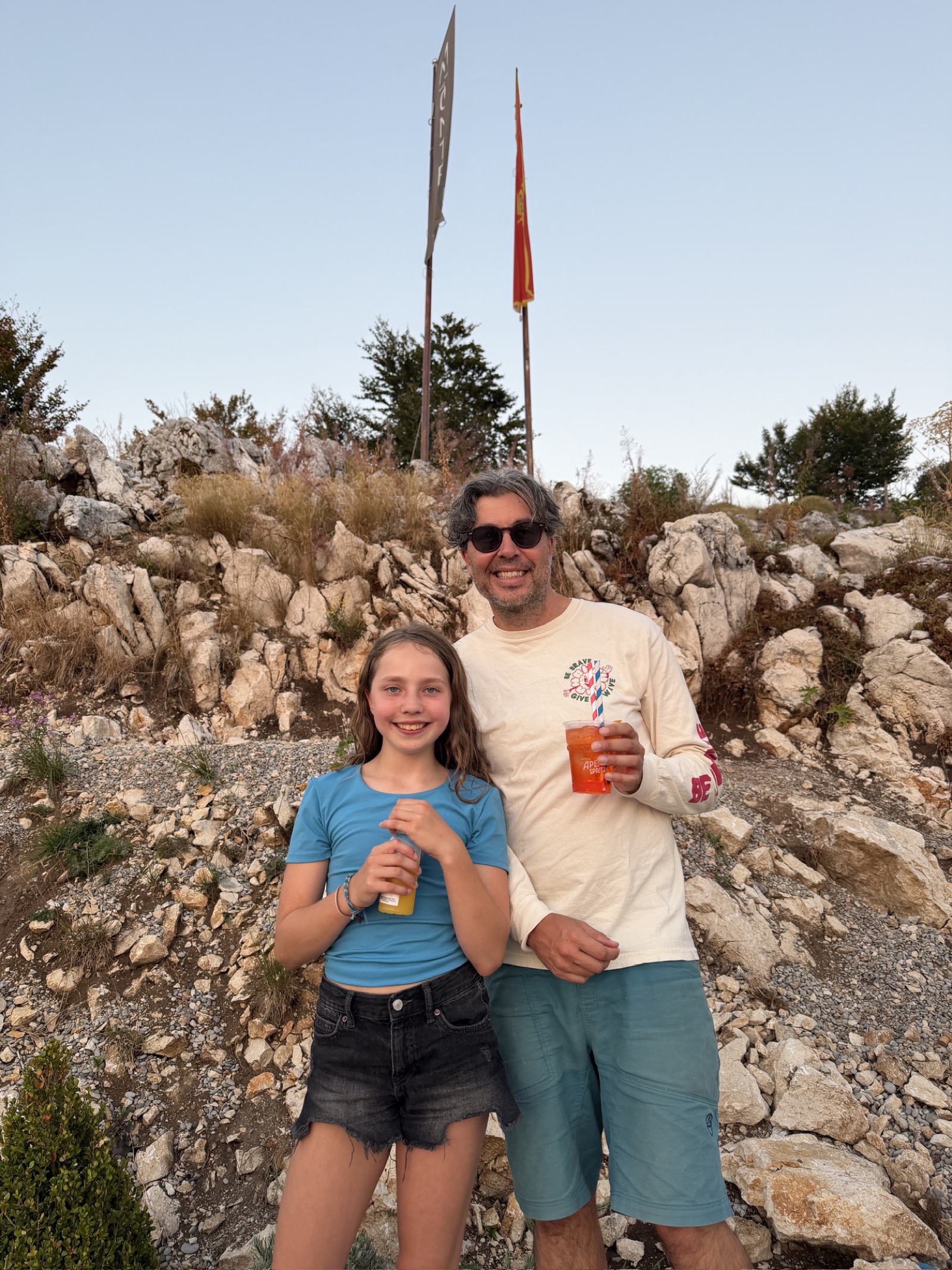 Adam and Leah having a toast on a rocky hilltop