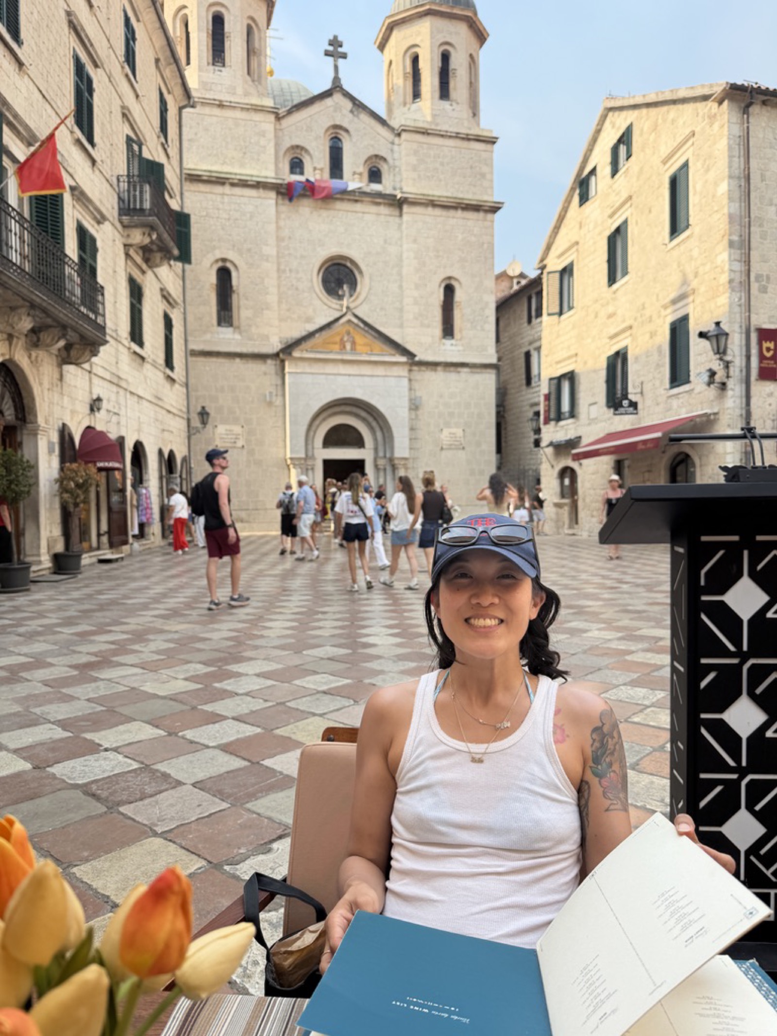 Natasha at a cafe table in Kotor's old town square